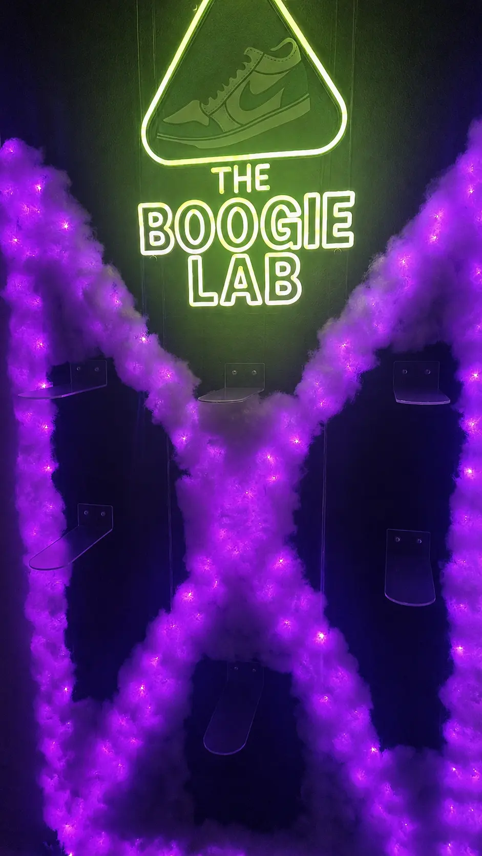 Neon-lit sneaker display wall in the studio