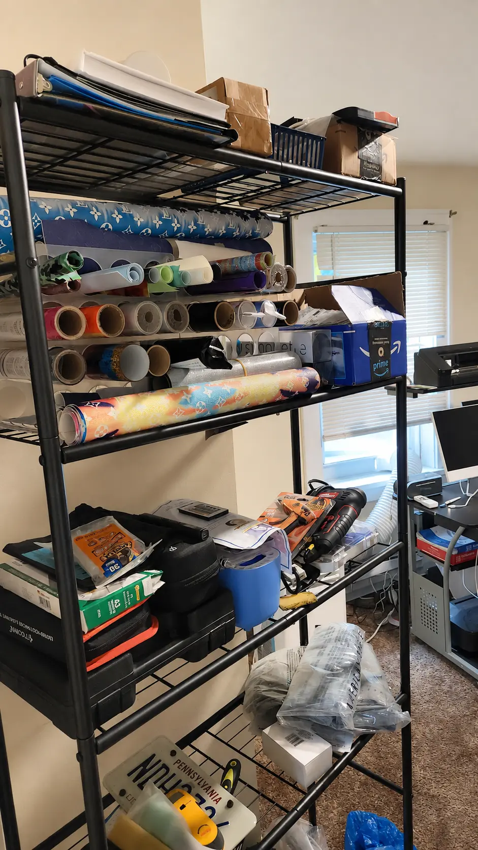 Shelving unit stocked with custom vinyl rolls, leathers and studio tools